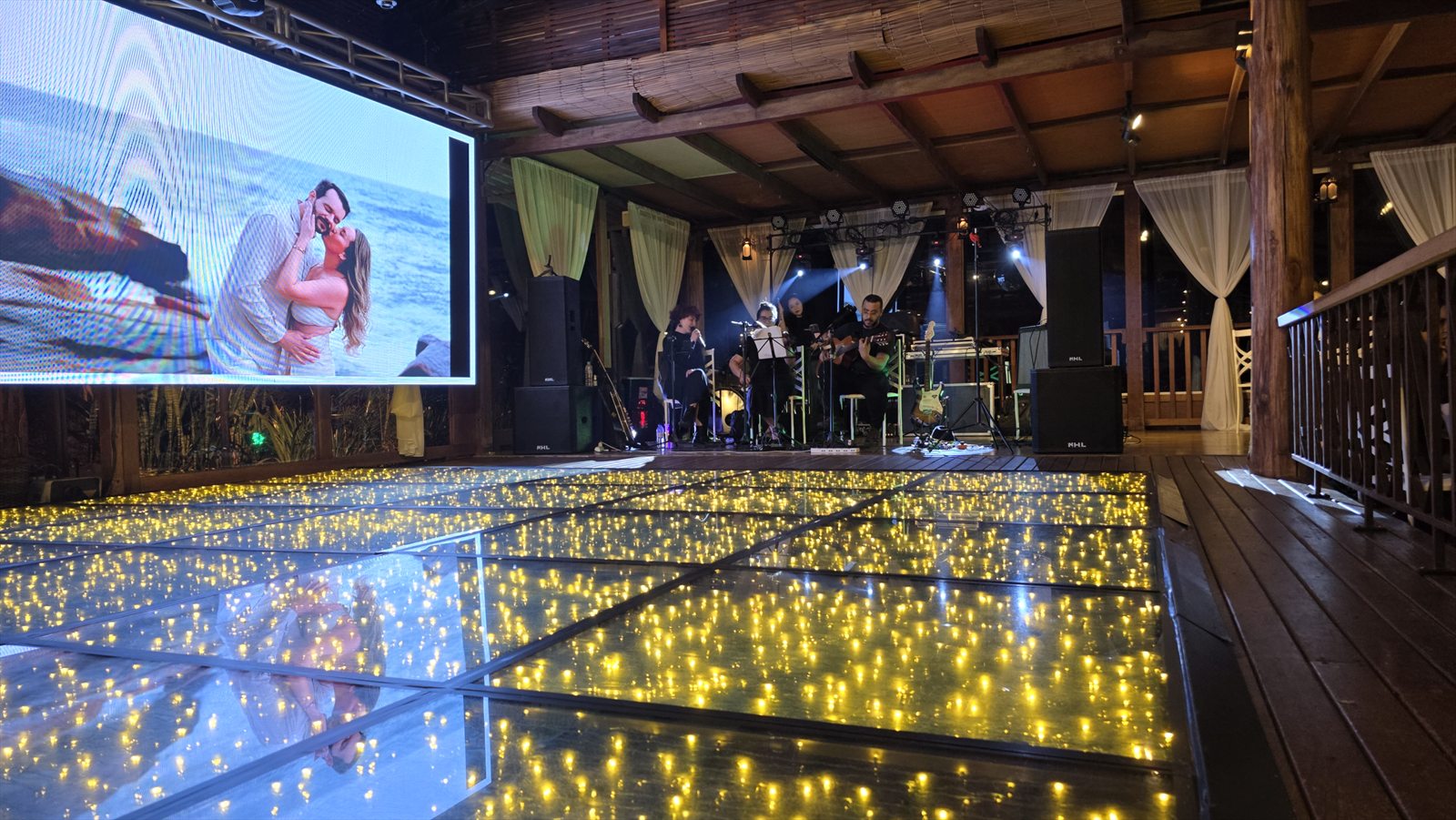 Palco, painel de LED e pista iluminada em casamento na chácara