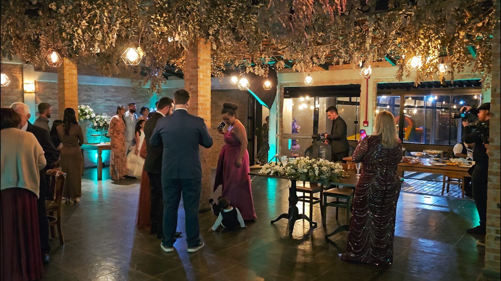 Recepção iluminada do casamento de Cristina e Maurício com convidados e decoração